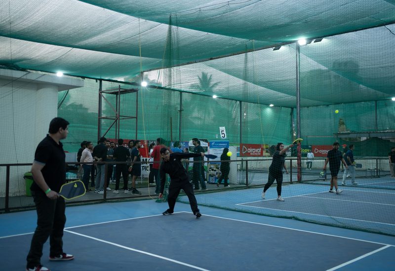 Investors and founders playing pickleball together on a padel court